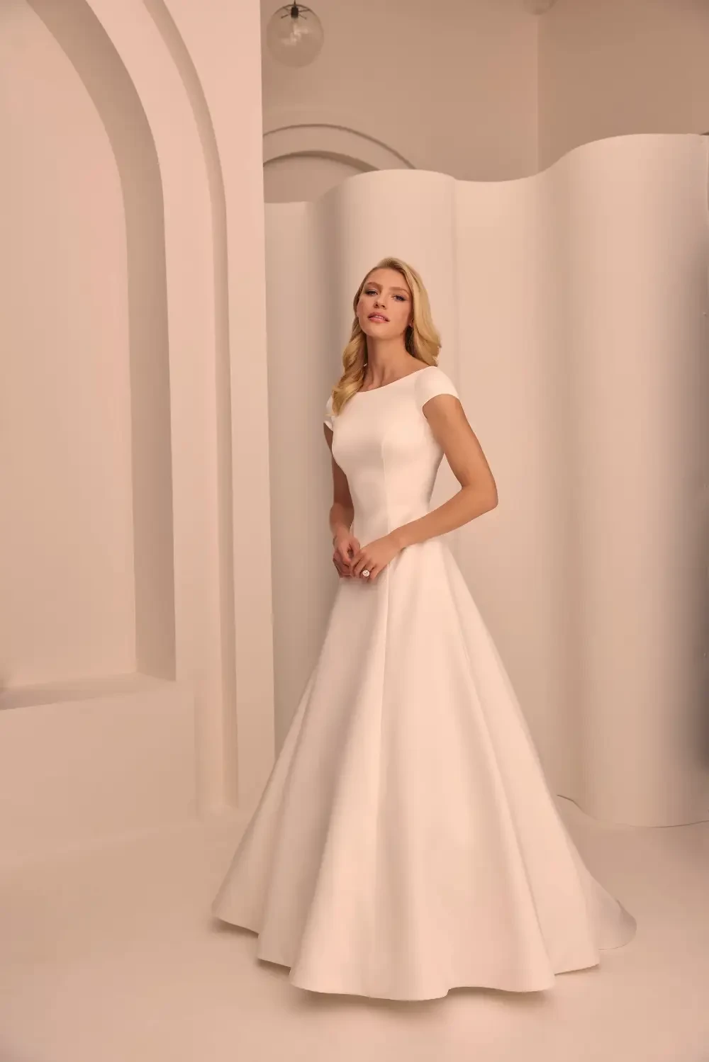 model is wearing a sleeveless minimalist bridal gown