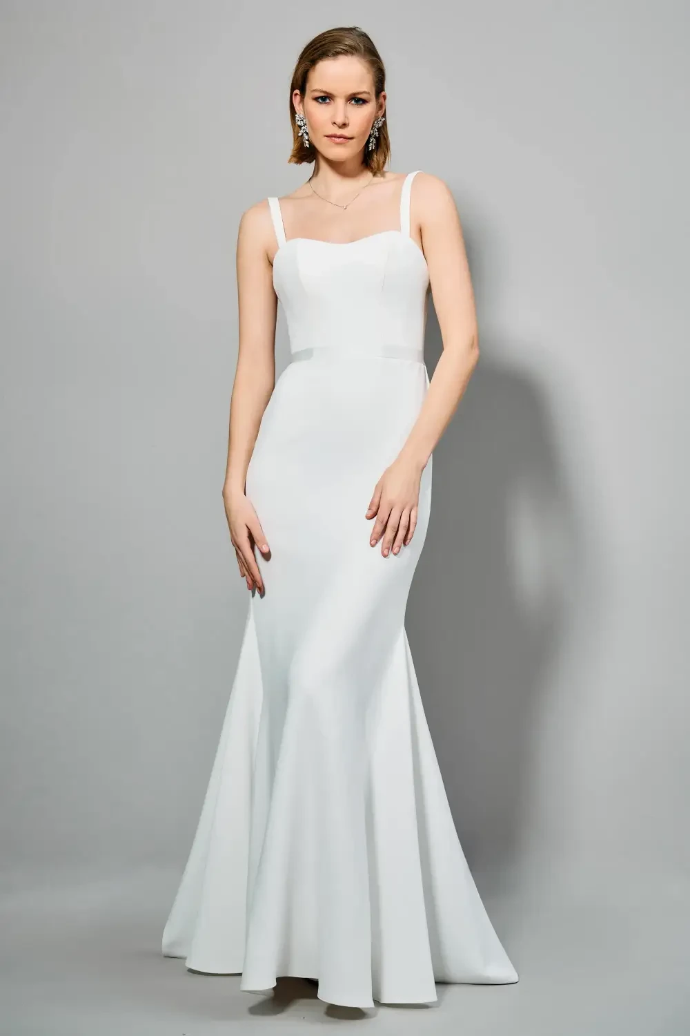 model is wearing a sleeveless backless bridal gown