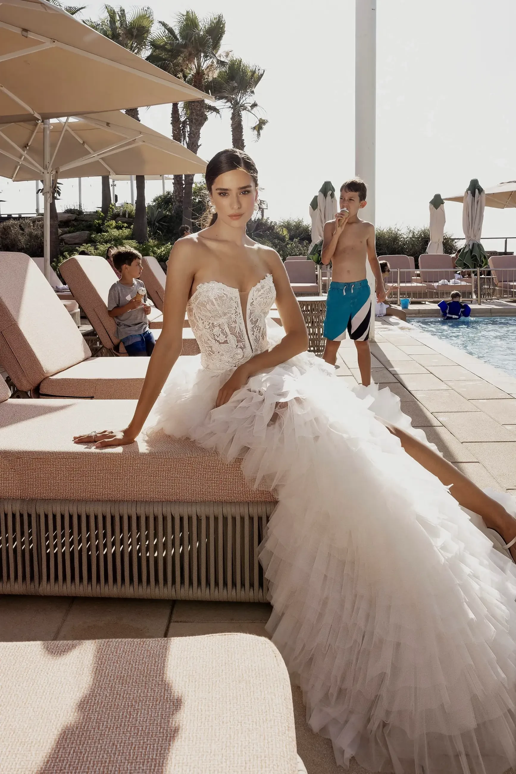Model is wearing a wedding dress with a detachable overskirt, plunging neckline, and 3D floral lace by gabrielle atelier 