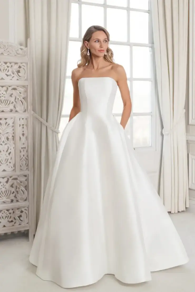 Model is wearing a sleek mikado strapless ball gown wedding dress