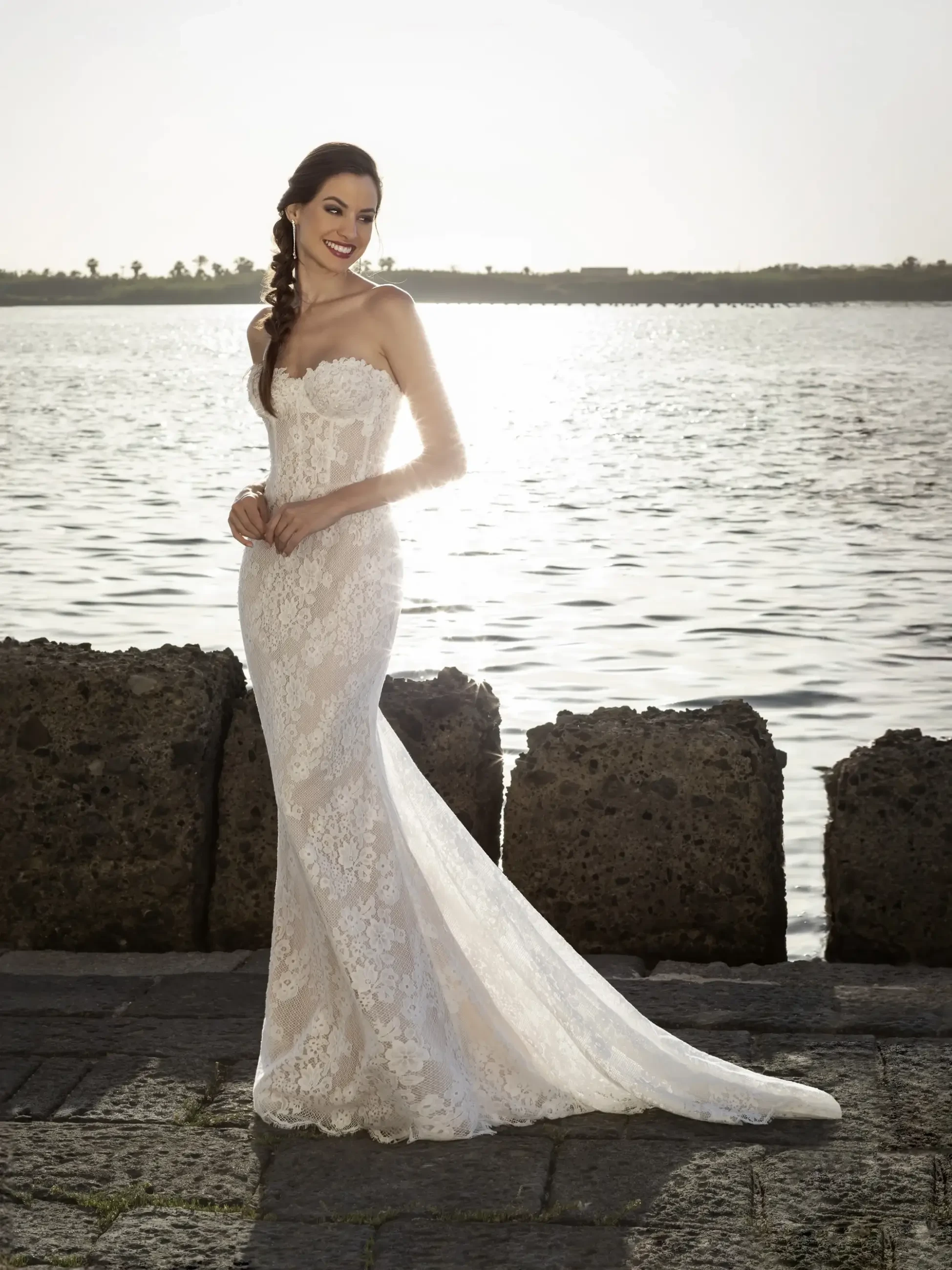 Model is wearing a strapless fit and flare allover lace bridal gown 